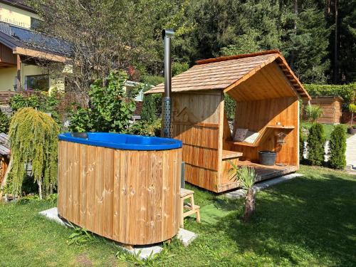 a wooden dog house and a hot tub in a yard at Haus Lasaun in Bressanone