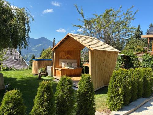 a wooden shed in a garden with a bed in it at Haus Lasaun in Bressanone