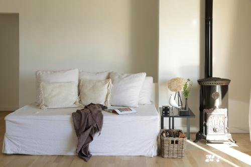a white bed with white pillows and a book on it at BlancdeBlanc in Yzerfontein