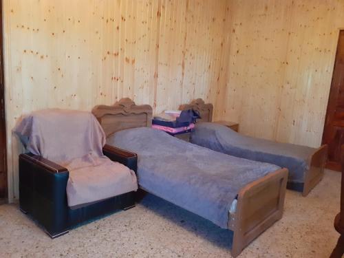 two beds in a room with wooden walls at Hostel Martvili Tasia in Martvili