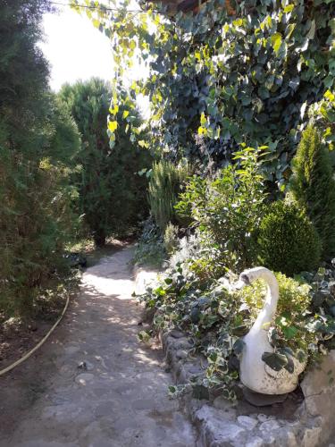a garden with a statue of a swan on a path at Hostel Martvili Tasia in Martvili