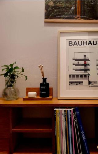 a table with a picture and a book shelf with books at OpenㆍJamsil Lake Stay in Seoul