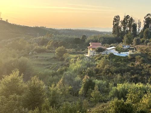 a house in the middle of a field with trees at NEW! Remote cosy apartment in Covas