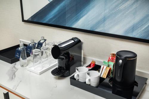 a counter with a coffee maker and cups on it at voco Jeddah Gate by IHG in Jeddah