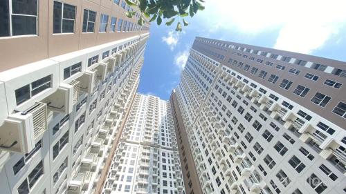 two tall white buildings looking up into the sky at Tokyo River side PIK2 By Micky Studio 5 in Muara