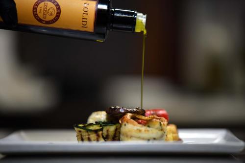 a bottle of wine being poured onto a plate of food at Cantina Langelina in Corinaldo