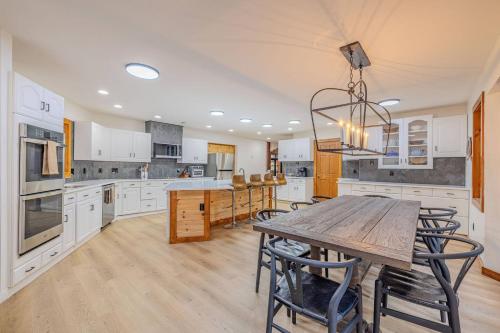 a large kitchen with white cabinets and a wooden table at Fall Break+Family Cabin+Game Room+Fire Pit+Hot Tub in Wear Valley