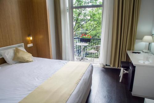 a hotel room with a bed and a large window at Hotel Larende in Amsterdam