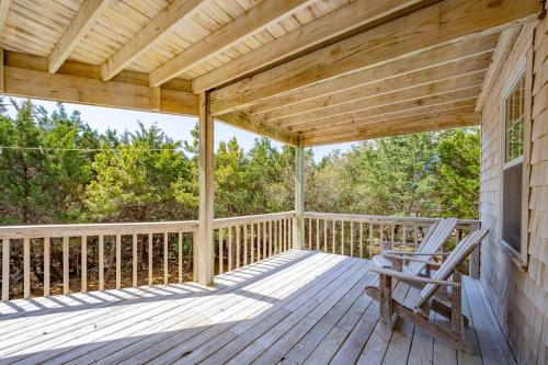 a wooden porch with a rocking chair on a deck at Hatteras High 65 in Frisco