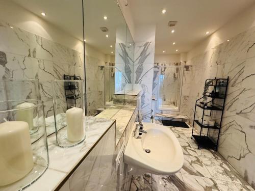 une salle de bain blanche avec un lavabo et un miroir dans l'établissement 3-Raum-City-Apartment Ost-5, à Düsseldorf