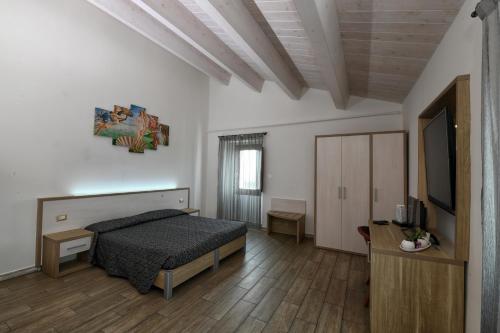 a bedroom with a bed and a flat screen tv at Cantina Langelina in Corinaldo