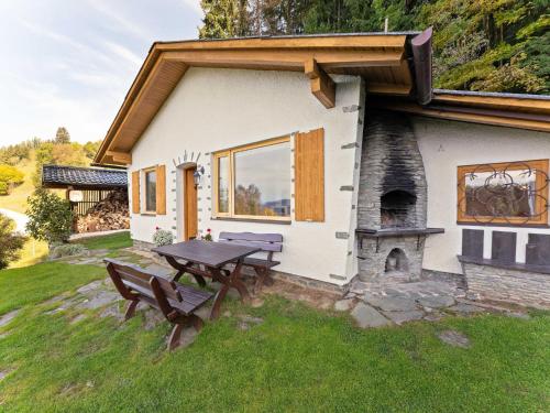 a picnic table in front of a house with a fireplace at Alpine Hut in Eberstein near Ski Area in Eberstein