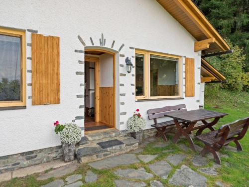 a picnic table and bench in front of a house at Alpine Hut in Eberstein near Ski Area in Eberstein