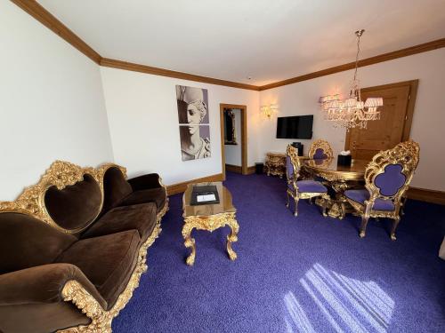 a living room with a couch and a table and chairs at Grand Hôtel du Golf & Palace in Crans-Montana