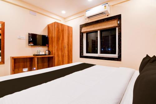 a bedroom with a white bed and a window at Hotel O Grand Inn in kolkata