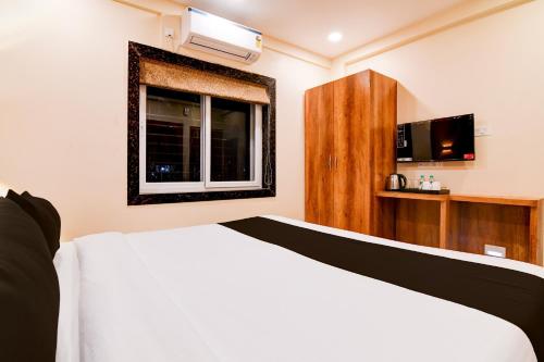 a bedroom with a white bed and a window at Hotel O Grand Inn in kolkata