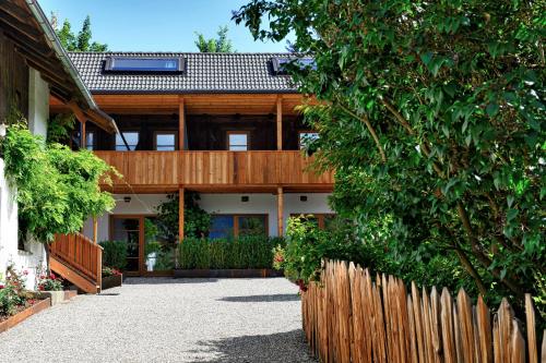 a house with a wooden fence in front of it at Apartments Mitterhof 1544 in Brunico