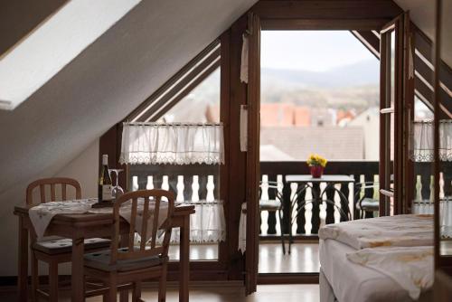 a room with a table and chairs and a balcony at Gästehaus Weingut Mangel in Endingen