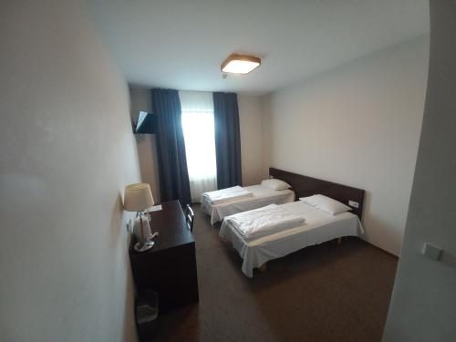 a hotel room with two beds and a window at Vlantana in Klaipėda