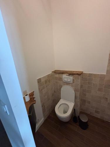 a bathroom with a toilet with a tiled floor at Studio proche de Jonzac in La Celle-sous-Gouzon