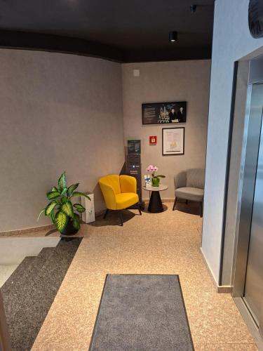 a lobby with a yellow chair and a couch at ibis Styles Pitesti Arges in Piteşti