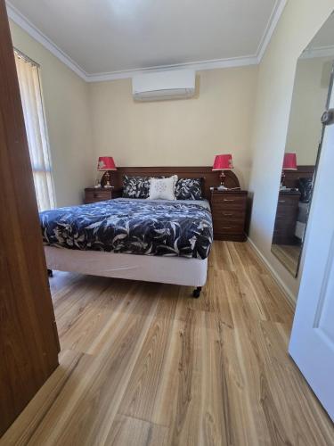 a bedroom with a bed and a wooden floor at Advantage house in Kelmscott