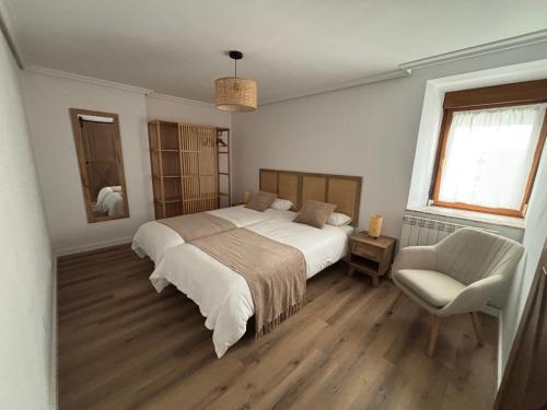 a bedroom with a large bed and a chair at El Refugio de los Corrales in San Mateo