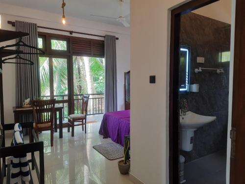 uma casa de banho com uma mesa e um lavatório num quarto em Turtle Point Homestay Seaview 2 - BB, Fast Wi-Fi, AC em Dikwella