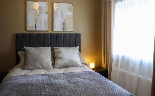 a bedroom with a bed with white pillows and a window at Campbell's in Augher