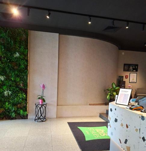 a lobby with a counter with a flower on it at ibis Styles Pitesti Arges in Piteşti