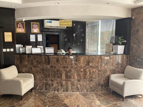 una hall con due sedie e un bancone della reception di فندق راحة السلام a Buraydah