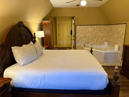 a bedroom with a large bed and a tub at Stonehurst Manor Breakfast & Dinner Included in North Conway