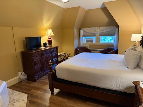 a bedroom with a large bed and a television at Stonehurst Manor Breakfast & Dinner Included in North Conway