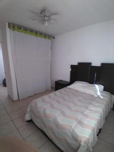a bedroom with a bed and a ceiling fan at Casa confortable in Silao