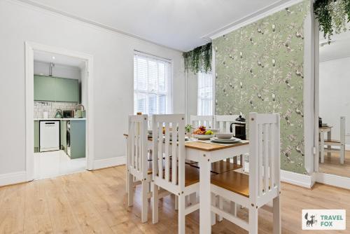 a white kitchen with a white table and chairs at Liz's 4 Bed House: Close to the Motor Point Arena in Nottingham