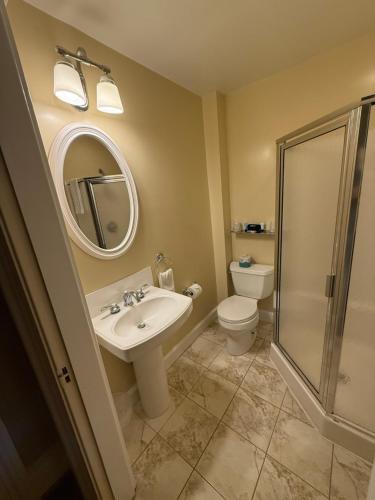 a bathroom with a sink and a toilet and a mirror at Stonehurst Manor Breakfast & Dinner Included in North Conway