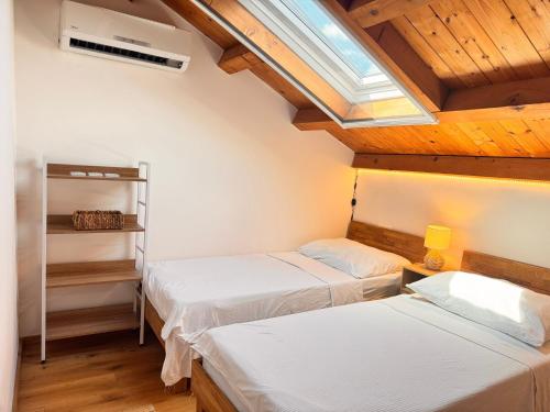 zwei Betten in einem Zimmer mit Holzdecken in der Unterkunft Luxus Haus direkt am Meer bei Novigrad in Dajla