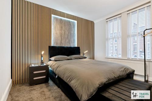 a bedroom with a large bed with a wooden wall at Liz's 4 Bed House: Close to the Motor Point Arena in Nottingham