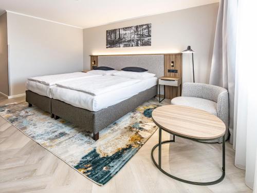 a bedroom with a bed and a table and a chair at Parkhotel Plzen Congress Center in Plzeň
