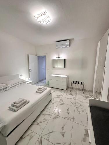 a white bedroom with a large bed and a bathroom at a casa di Luca in Florence