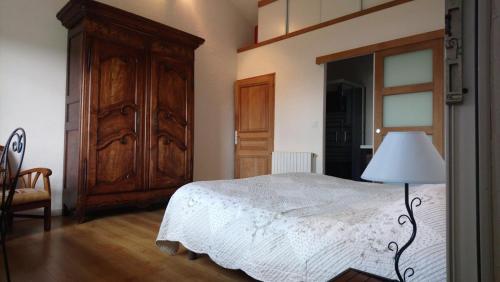 sypialnia z łóżkiem i dużą drewnianą szafą w obiekcie Grange du Lac Clair w mieście Saint-Savin
