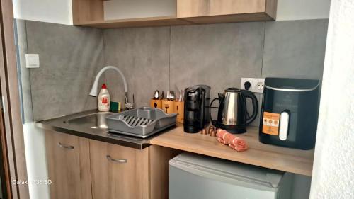 a kitchen counter with a sink and a coffee maker at SunWaves Apartments in Keramotí