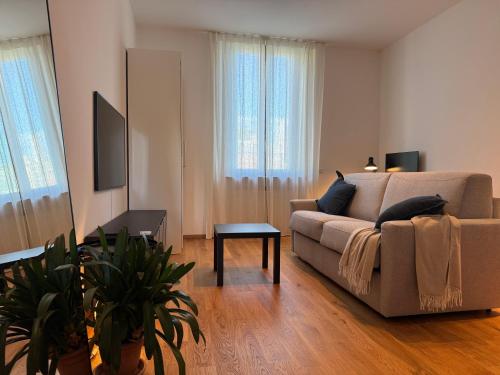a living room with a couch and a table at Comfort Stay Legnano - Appartamento di 85m2 con 2 bagni, Smart TV, WiFi ultra veloce e angolo lavoro, perfetto per visitare Milano in relax in Legnano