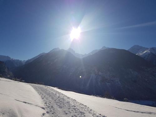 a sun is shining on a snow covered mountain at Blick Auf Herrliche Bergwelt in Schmitten