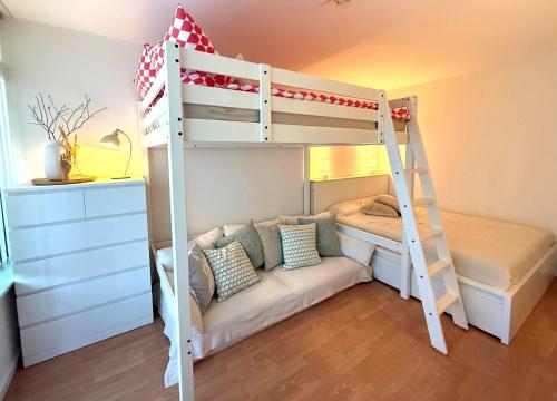 a bedroom with a bunk bed with a couch under it at Strandbude 4 in Dahme
