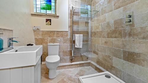 a bathroom with a toilet and a sink and a shower at Myrtle Cottage in Longhope