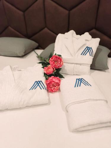 a pile of towels and roses on a bed at Dvor Aaki in Novi Vinodolski