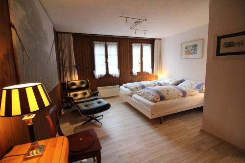 a bedroom with a bed and a chair at Gartenwohnung Bemer Rempfler Erholung Pur in Lungern