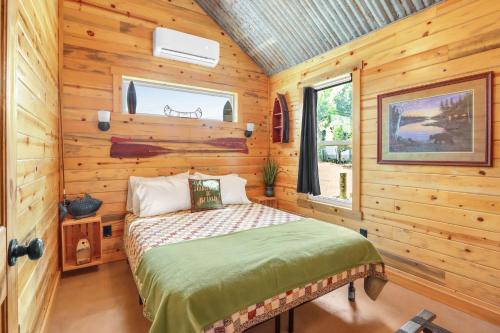 une chambre avec un lit dans une cabane en bois dans l'établissement RusTx Ranch Cottage Group 4-6, à Wimberley