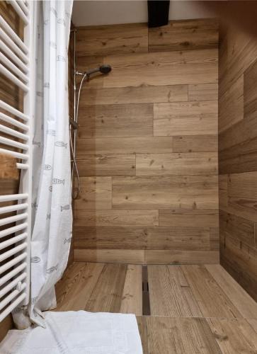 a bathroom with a shower with a wooden wall at Haus Am See Mühlruh in Horn